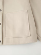 Cream-colored pocket detail with perforated buttons on Langry single breasted jacket