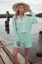 Woman in mint green stylish shorts knitting set with straw hat