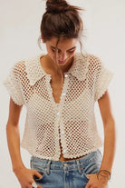 Cream-colored crochet cardigan loose knitwear top with short sleeves and blue jeans