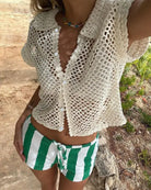 White cardigan loose knitwear top with green and white striped shorts