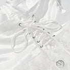 White lace-up boot with silver eyelets on early spring floral dress