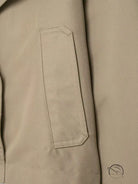 Beige double breasted short trench coat with laptop sleeve pocket