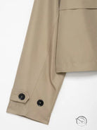 Casual double breasted short trench coat in beige with black buttons and pockets