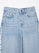 Light blue wide leg denim jeans with distressed patches and crochet stitching