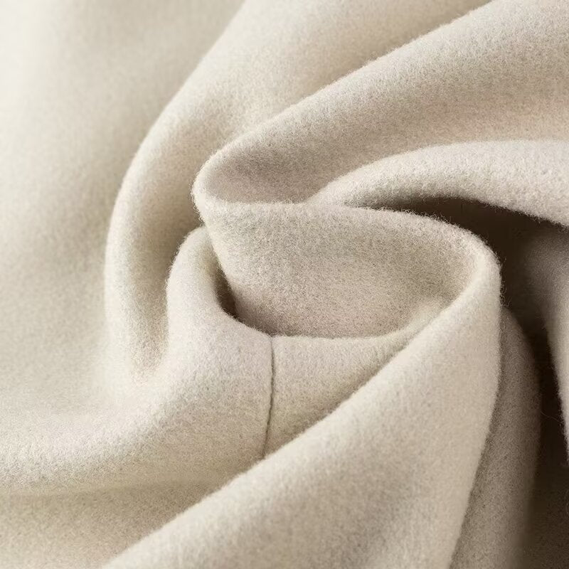 Cozy cream-colored plush blanket with soft folds in Langry fashion trench coat