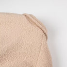 Beige textured bath towel with folded corner in Langry double breasted fashion overcoat