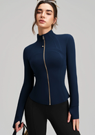 Navy blue long sleeve yoga jacket with gold zipper and black leggings