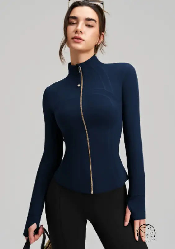 Navy blue long sleeve yoga jacket with gold zipper and black leggings