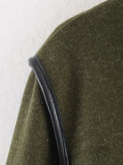 Olive green textured fabric with black leather strap on langry fashion coat