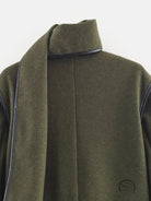 Olive green langry wool coat with black trim and high collar for cozy fashion