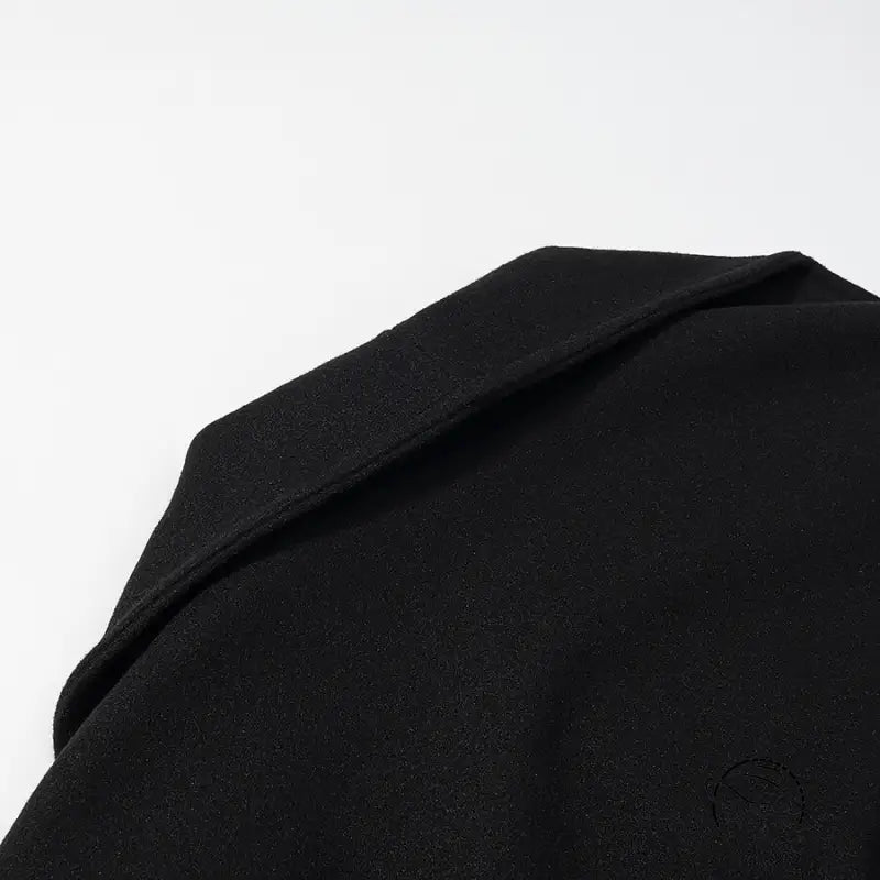 Elegant woolen coat in black wool with lapel collar and button detail