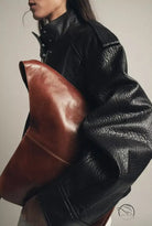 Langry faux leather bomber jacket with brown leather clutch bag and black high collar