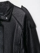 Elegant langry faux leather bomber jacket with textured black surface and snap buttons