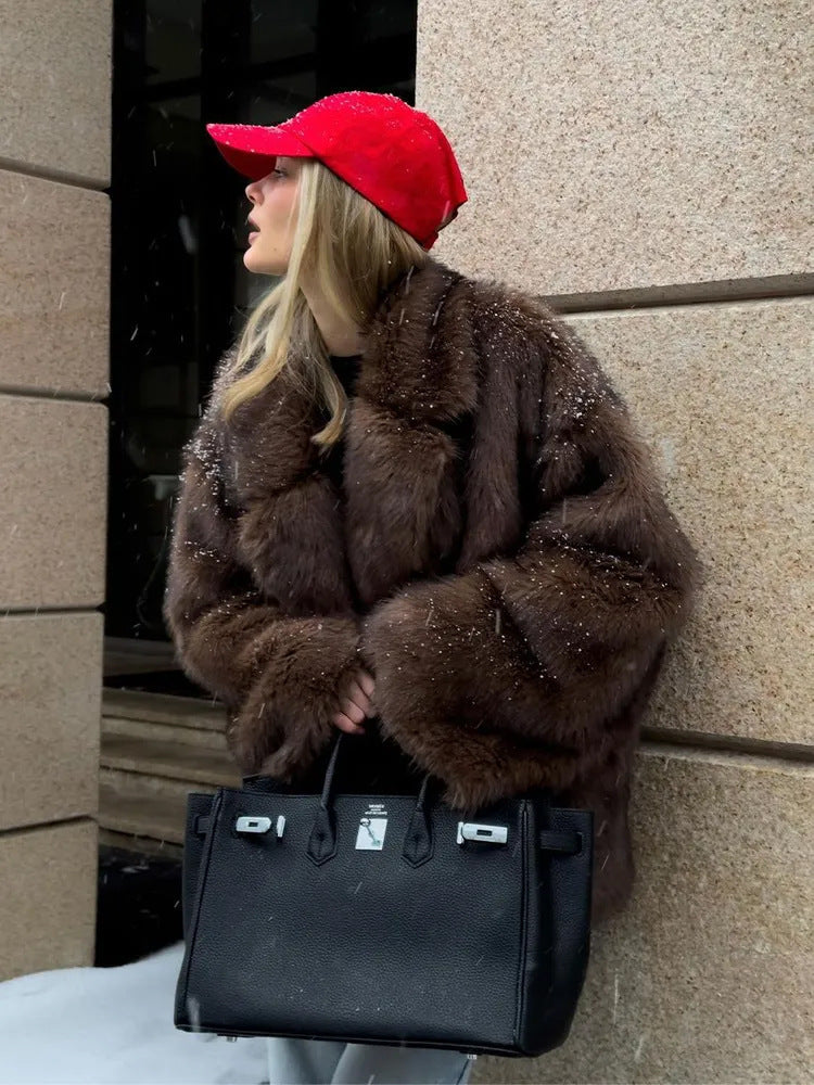 Fashionable faux fur coat with black leather Hermès Birkin handbag and silver hardware