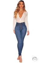 Woman in white bodysuit and skinny denim blue high-waisted jeans