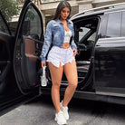 Woman in loose short denim coat with lace bralette and denim shorts