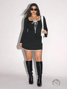 Elegant sweet spicy dress: woman in black and white trim with knee-high boots