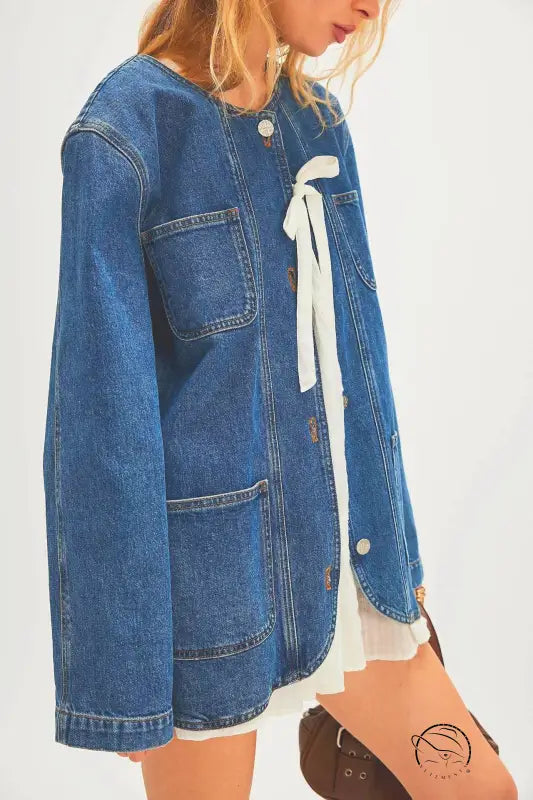 Woman modeling casual fashionable cowboy coat in blue denim with ribbon ties and pockets