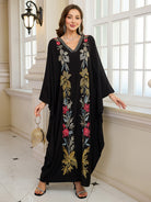 Elegant embroidered Middle East kaftan dress with black floral pattern, gold accents, v-neckline, and langry sleeve length