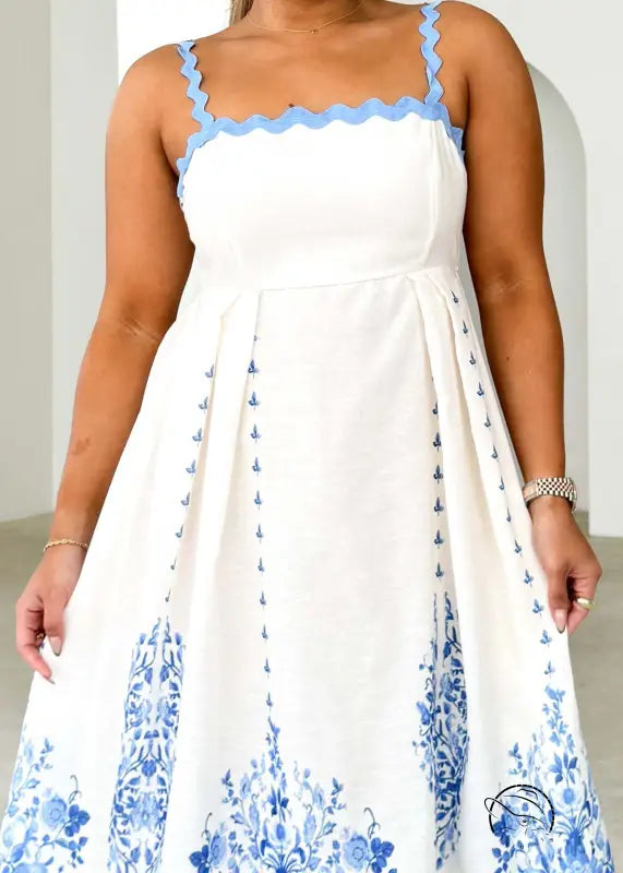 Attractive backless dress in white with blue floral embroidery and scalloped straps