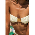 White bandeau bikini top with gold sunburst medallion, perfect for fashion enthusiasts