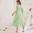 Woman in gorgeous high waist voile A-line dress with mint green midi, sheer long sleeves, layered tulle skirt