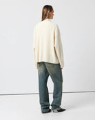 Cozy Langry fashion wool cardigan sweater with regular sleeve, cream knit, black buttons, pockets, and dark wash jeans