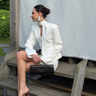 Langry fashion white high-neck blouse with bell sleeves and black clutch