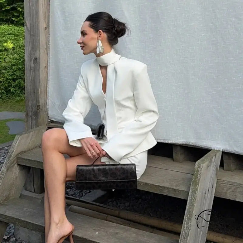 Elegant langry fashion white high-neck blouse with bell sleeves and black clutch bag in waist-tight blazer hip skirt two-piece set