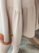 Beige tiered midi dress with long sleeves and ruffled hem for winter fashion