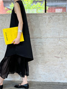 Black sleeveless elegant Korean style dress with pleated bottom and yellow folder accessory