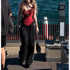 Handmade lace boning corset in red with black pants and floral embellishments