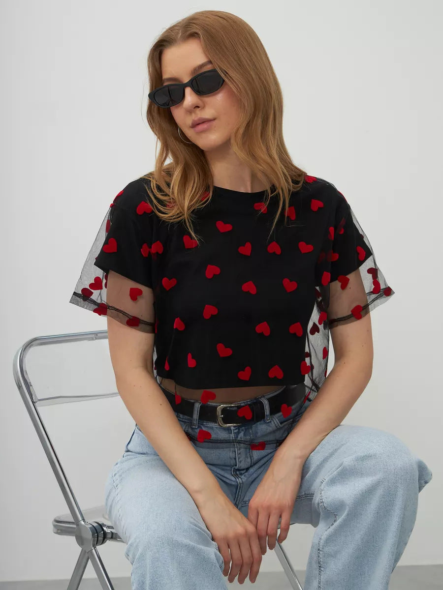 Black mesh top with red heart patterns paired with light blue jeans for trendy fashion ملابس