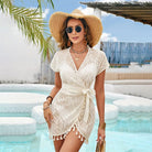 White tassel-trimmed wrap dress with short sleeves and tie waist for boho beach fashion