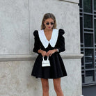 Black dress with white collar highlighting French fashion in ملابس design