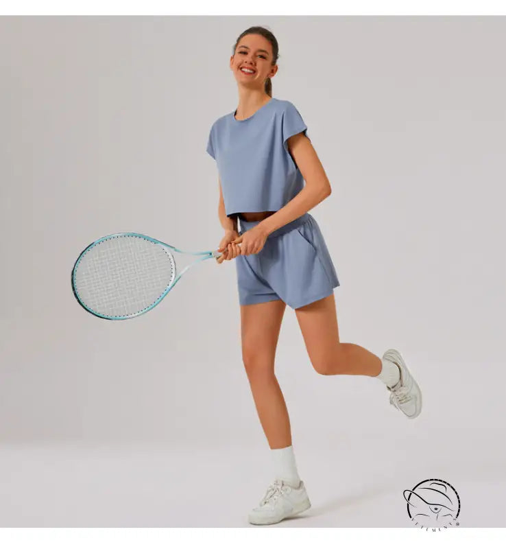 Tennis player in loose sports yoga set posing mid-motion with racquet