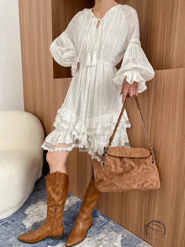 Stunning layered dress in white ruffles with brown boots and handbag
