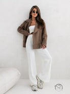 Woman in langry collared woolen brushed zipper coat in brown jacket and white pants