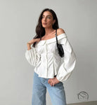 Elegant French off-shoulder shirt with billowy sleeves and light blue jeans
