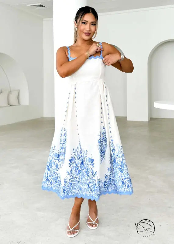 Attractive backless dress in white with blue floral embroidery on hem and straps