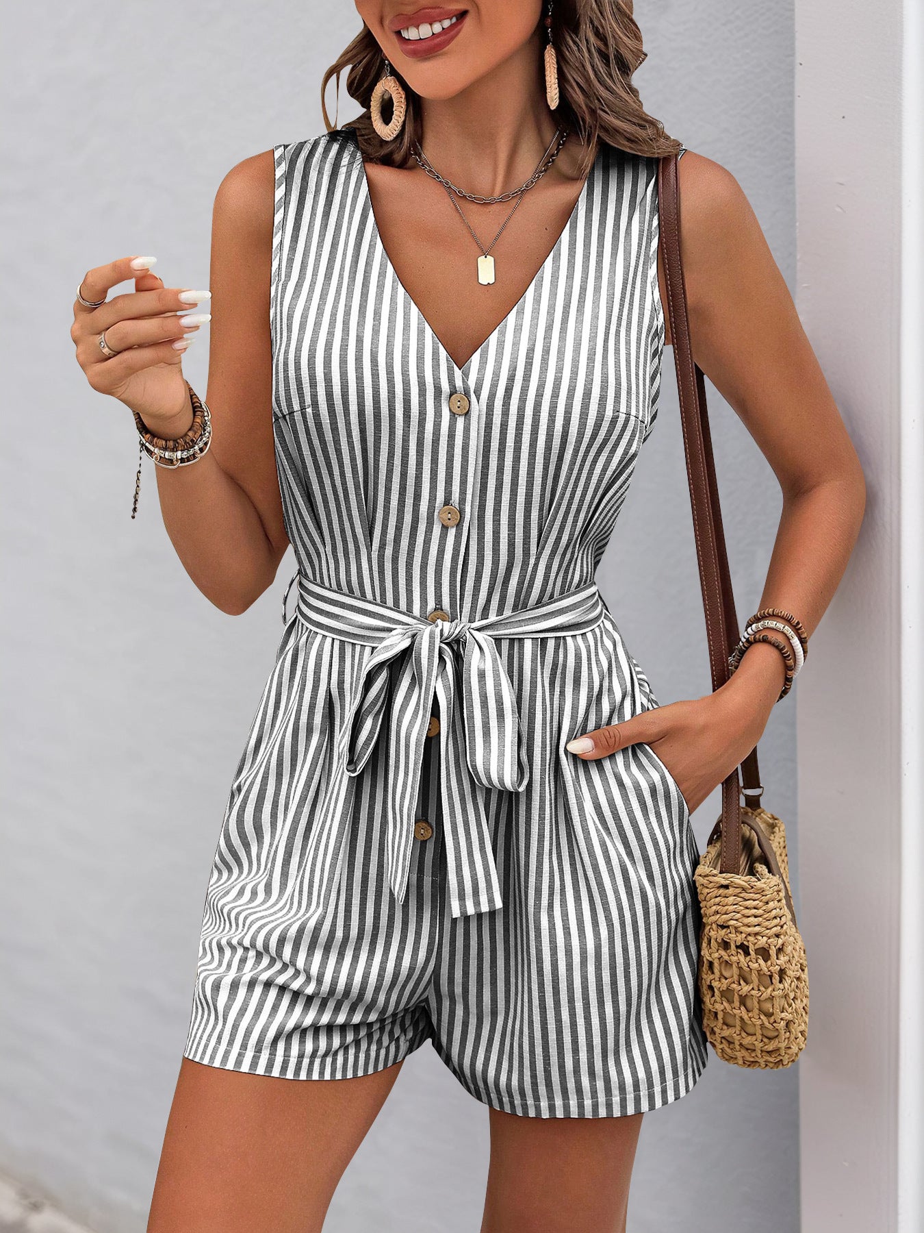 Sleeveless striped romper with v-neck, buttons, pockets, and waist tie for summer fashion