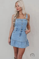 Office suspenders denim dress in light blue with button-front bodice and ruffled hem