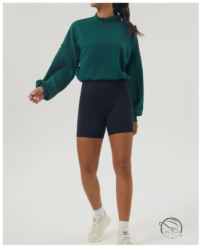 Woman in green autumn winter thickened sweater and black shorts