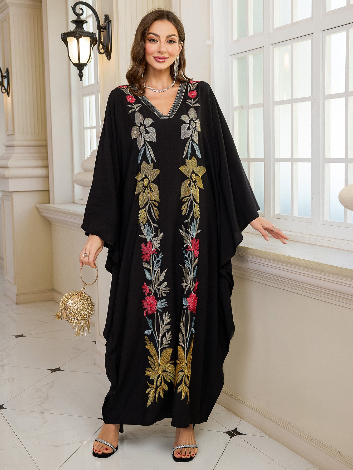 Elegant embroidered Middle East kaftan dress with black floral pattern, gold accents, v-neckline, and langry fashion