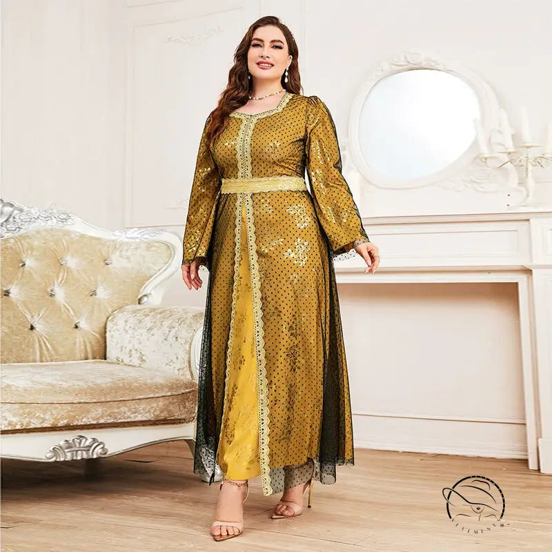 Woman in loose long sleeve A-line dress with golden-yellow fabric, black polka dots, and lace trim