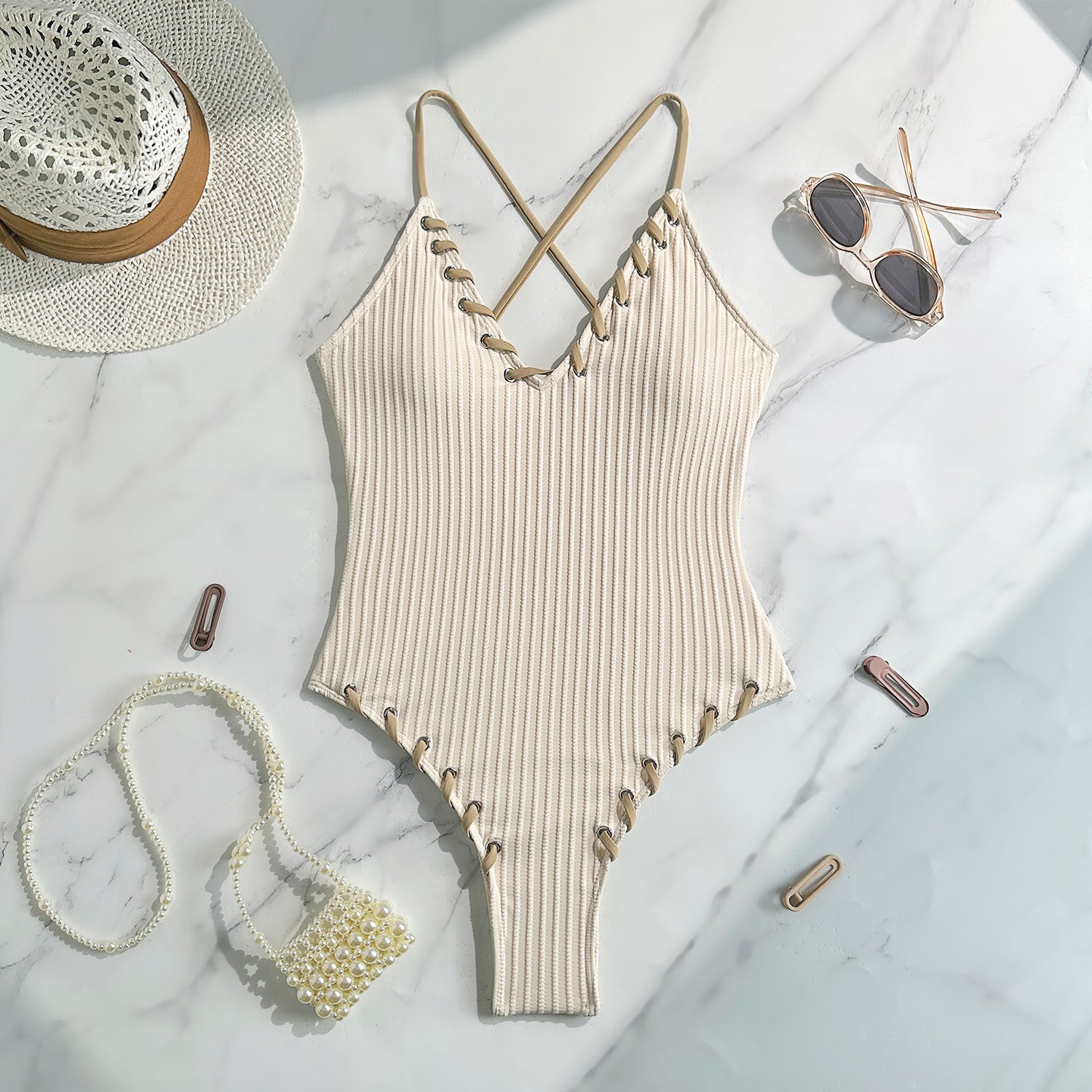 Cream-colored ribbed one-piece swimsuit with crisscross straps and scalloped edges in fashion