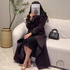 Langry fashion black quilted handbag with gold-tone hardware in trench coat display