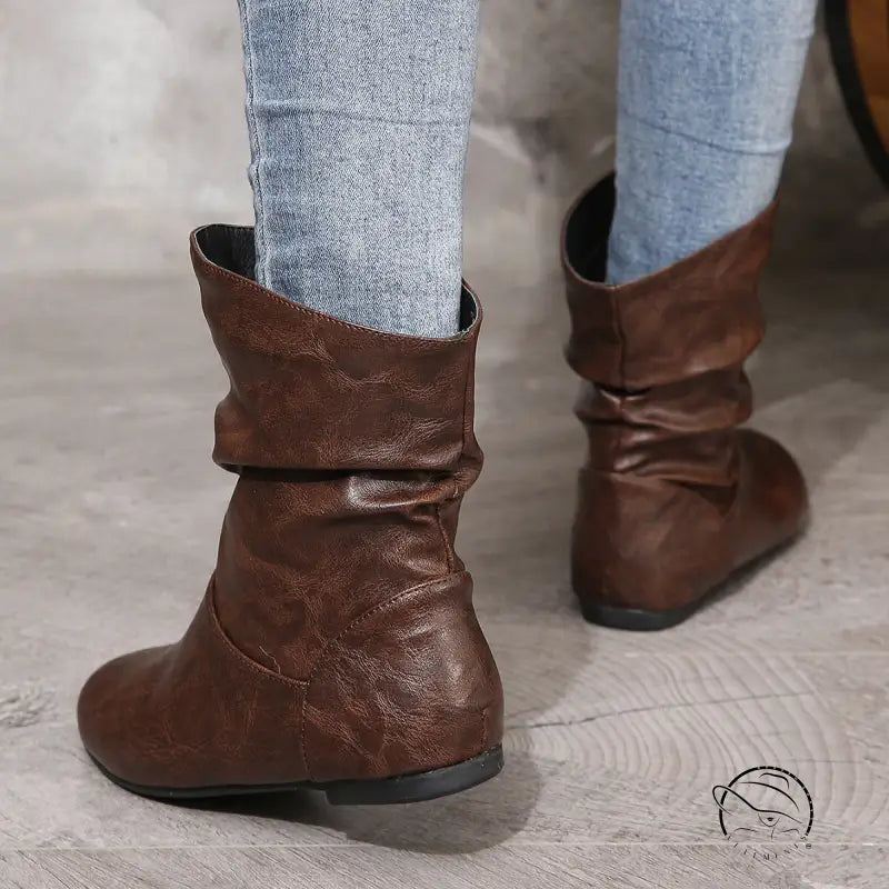 Low heel faux leather boots with jeans tucked in
