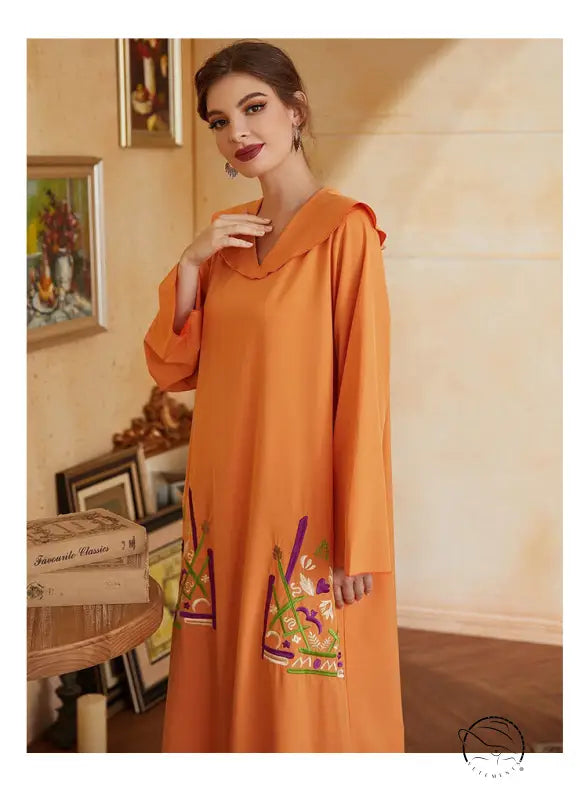 Beautiful orange long-sleeved fashion dress with hood and floral bag