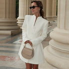 Elegant cardigan buckle waist slimming dress in white with gold buttons and black sunglasses